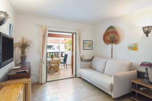 un soggiorno con un divano e una televisione di Nueva Playa a Denia