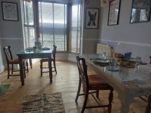 a dining room with a table and chairs and a window at Velo Club Mumbles in Oystermouth
