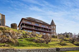 a large building on top of a grassy hill at Penthouse Golf View Apartments in Lossiemouth