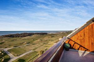 a view of the ocean from the balcony of a house at Penthouse Golf View Apartments in Lossiemouth +10 photos