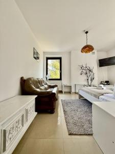 a living room with a couch and a bed at EASY RENT Apartments - Willa Alba in Nałęczów