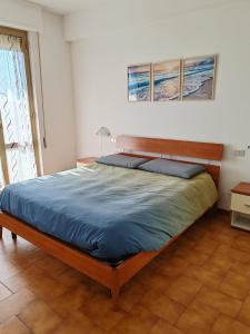 a bedroom with a large bed with blue sheets at Condominio melograno in Rosignano Solvay