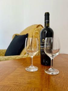 a bottle of wine and two wine glasses on a table at EASY RENT Apartments - Willa Alba in Nałęczów
