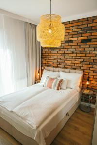 a bedroom with a large bed with a brick wall at Apartament Ulubiony Mariental Residence in Szklarska Poręba