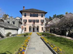 una grande casa bianca con un sentiero di fronte a un cortile di Appartamento vacanze al lago Orta San Giulio a Orta San Giulio