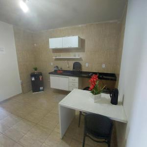 a kitchen with a table and a white counter top at Flat estação in Juazeiro do Norte +21 photos