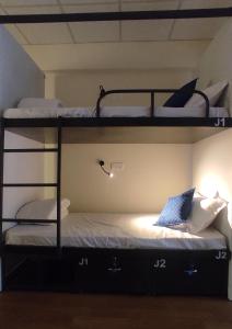 een slaapkamer met 2 stapelbedden en een laptop. bij Hostells in Pune