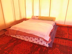 un piccolo letto in una stanza con media di Camp Les Bedouins iriki a Bou Guir Altre 5 foto