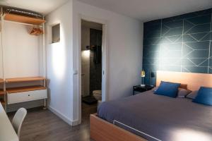 a bedroom with a bed with a blue accent wall at Suite 5 in Cala del Moral