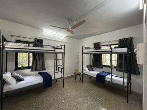 two bunk beds in a room with a ceiling at Tripvana Backpacker Hostel in Nashik