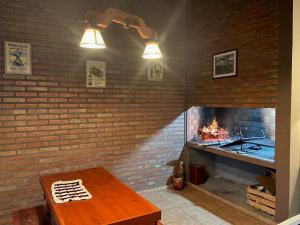 a brick fireplace with a wooden table in front of it at Cabañas Abril in Merlo