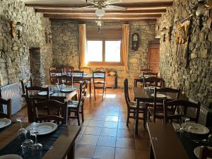 a restaurant with tables and chairs in a room at Fonda Carrera in Labuerda