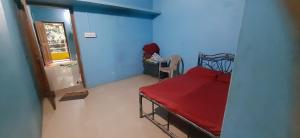 a small room with a bed and a blue wall at Sharvati Backwater Homestay in Haldipur