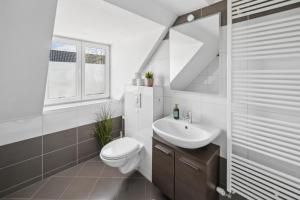 a white bathroom with a sink and a toilet at Larooms - Nula#3 in Merseburg +11 photos