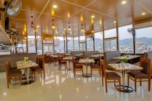 ein Restaurant mit Tischen und Stühlen und Fenstern in der Unterkunft Jasoda Heritage Hotel in Jaipur
