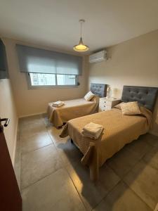 a room with two beds and a window at Departamento 3 Habitaciones Zona Cincuentenario in Formosa