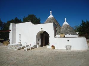 a small white church with a bench in front of it at Trullo del Paradiso and pool in Ostuni