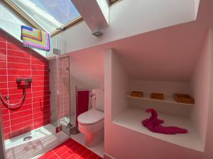 a bathroom with a toilet and a shower with red tiles at Relax Los veleros in Pasito Blanco +45 photos