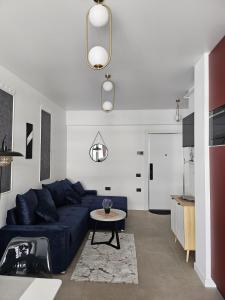 a living room with a blue couch and a table at Apartament mamaia nord - Alezzi odyssey in Mamaia Nord