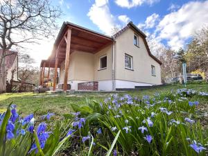 a house with purple flowers in the yard at Ferienhaus Emma Dresden Hellerau in Dresden