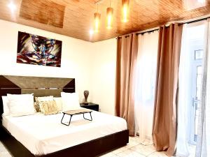 a bedroom with a bed with a table on it at Maison Chic et confortable à la poste centrale in Yaoundé