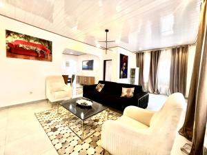 a living room with a couch and chairs and a table at Maison Chic et confortable à la poste centrale in Yaoundé