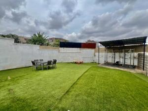 a large yard with a table and chairs on a building at Maison Chic et confortable à la poste centrale in Yaoundé