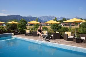 eine Frau springt in einen Swimmingpool in der Unterkunft Hotel Sommer-Haus am See in Füssen