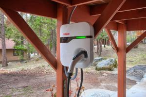un téléphone public est fixé à une structure en bois dans l'établissement Acorn Alley Inside Yosemite - Dog Friendly w/Hot tub, Fire pit, EV Charger, à North Wawona