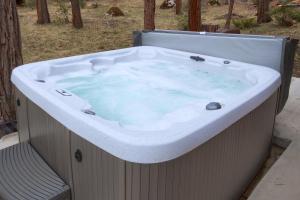 une grande baignoire remplie d'eau bleue dans la cour dans l'établissement Acorn Alley Inside Yosemite - Dog Friendly w/Hot tub, Fire pit, EV Charger, à North Wawona