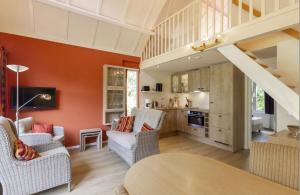 a living room with orange walls and a staircase at Bungalowpark Simpelveld - Delta 121 in Simpelveld