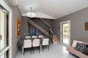 a dining room with a table and chairs and a staircase at President Villa Tuerredda in Chia
