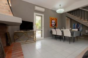 a dining room with a table and a television at President Villa Tuerredda in Chia +46 photos