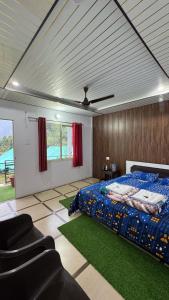 a bedroom with a bed and a couch and chairs at Kedarnath Wildlife Resort in Gupta Kāshi