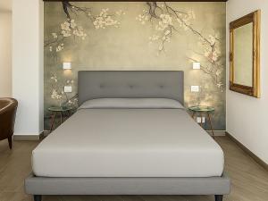 a bed in a bedroom with flowers on the wall at Relais Al Porto in Peschiera del Garda