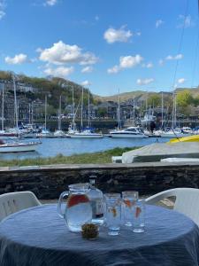a table with a teapot and glasses on a table with boats at Georgina Portview- Pet Free-Allergy Friendly in Porthmadog