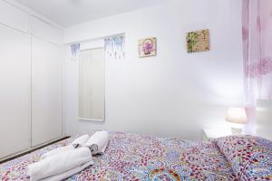 a bedroom with a bed with towels on it at Lovely Acapulco Playa de Las Americas in Playa de las Americas +24 photos