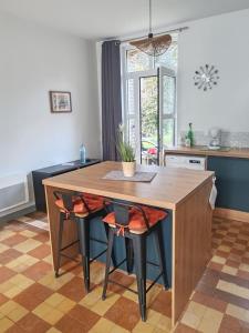 a kitchen with a wooden table and chairs at Maison en briques au 10 in Lamberville
