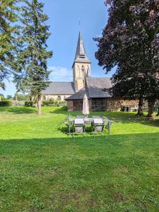 a group of picnic tables in front of a church at Maison en briques au 10 in Lamberville