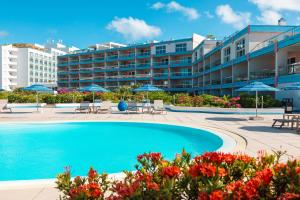 a swimming pool in front of a hotel at Royal Islander Club Resort La Terrasse in Lowlands