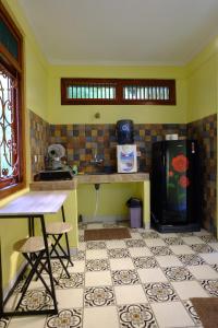 a kitchen with a refrigerator and a table and chairs at Villa Alicia - Pavillion Lily in Yogyakarta +16 photos