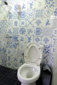 a bathroom with a toilet with blue and white tiles at Villa Alicia - Pavillion Lily in Yogyakarta