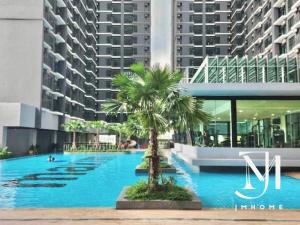 a swimming pool with a palm tree in front of a building at Majestic Maxim UCSI 2R near MRT #22 in Kuala Lumpur