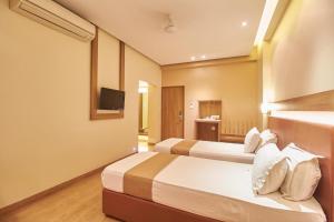 萨塔拉Hotel Rajtara的有两张床和一台电视的酒店房间