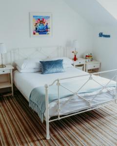 una camera con un letto bianco e due comodini di Dawn Break Guest House a Largs