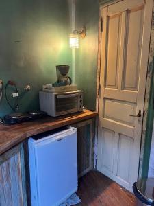 a kitchen with a microwave on a counter next to a door at mercado NL in Villa La Angostura