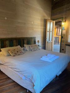 a large bed with two towels on top of it at mercado NL in Villa La Angostura