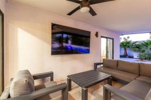 a living room with a couch and a ceiling fan at Luxury 4BR Retreat Heated Pool, Mini Golf and BBQ in Phoenix
