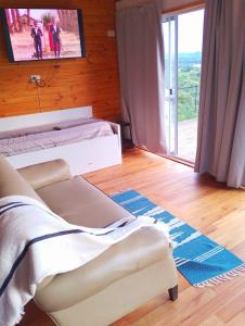ein Schlafzimmer mit einem Bett und einem Fernseher an der Wand in der Unterkunft Družina Embalse Calamuchita in Embalse