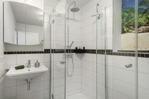 デッゲンハウザータールにあるFerienwohnung Auszeitの洗面台とシャワー付きの白いバスルーム +12枚の写真
